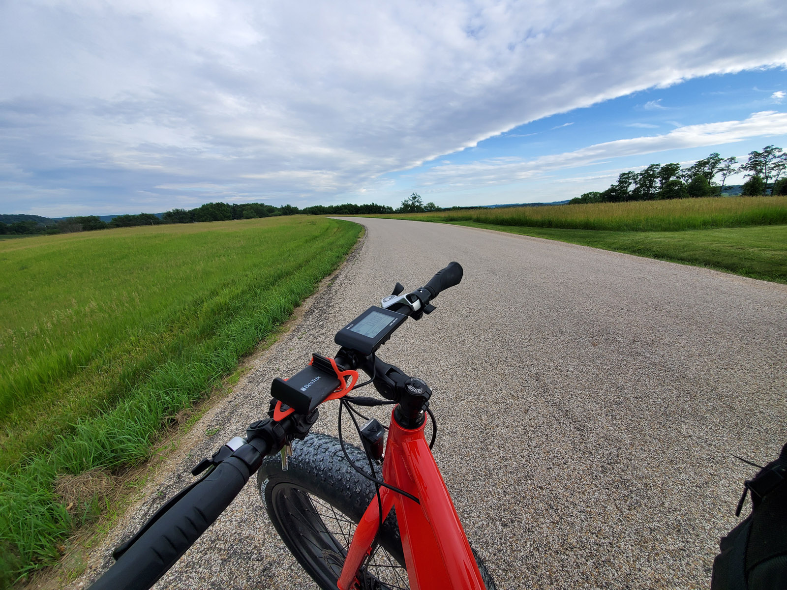 A person riding a bike overlooking the scenic Galena River Trail and fields.